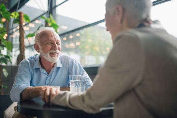istock Senior couple holding hands on a date at coffee shop 1002872008
