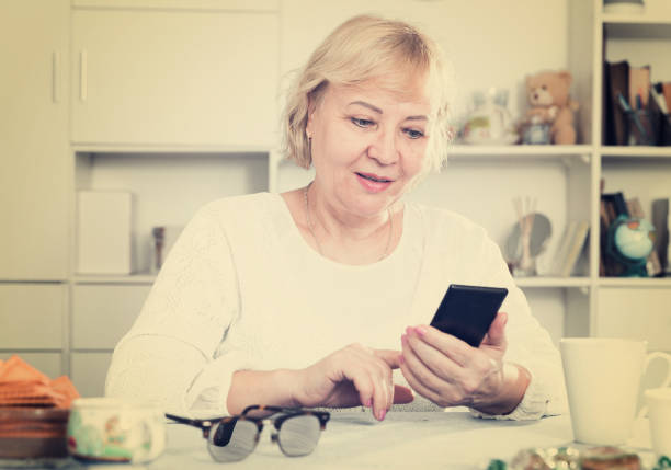 istock Mature woman with smartphone 1002873010