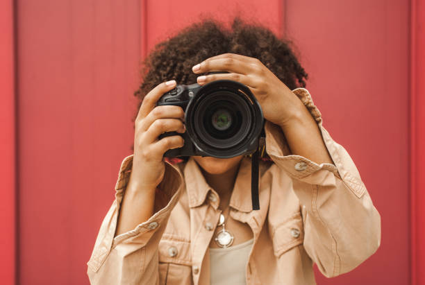 istock young african american woman using digital camera on street 1002873938