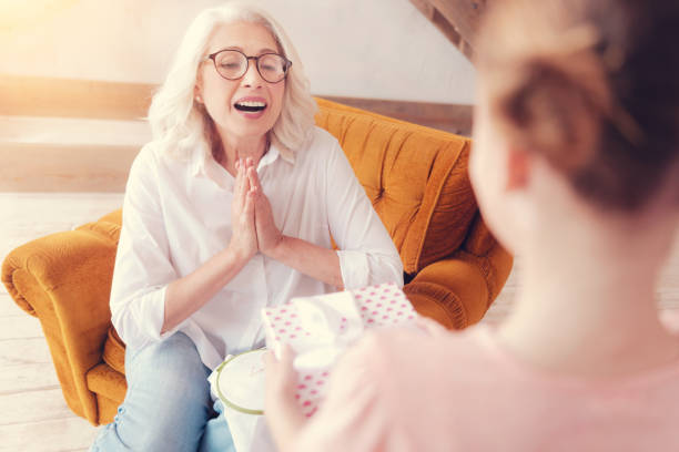 istock Amazed retired lady getting emotional while receiving gift 1002877528