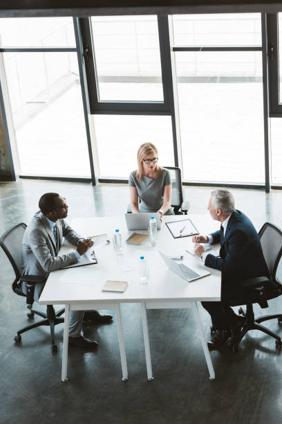 istock high angle view of professional multiethnic business people working together at table in modern office 1002877792