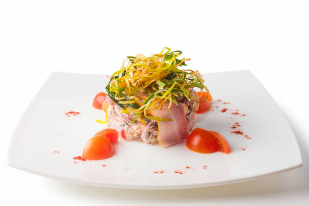salad with bacon, meat and vegetables, onion and cherry tomatoes on a white plate, isolated
