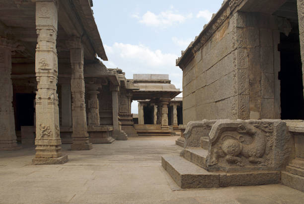 Finely carved columns of the entrance porch, side (north) porch of ardhamandapa in the centre and the entrance to the kalyana mandapa on the right side. Hazara Rama Temple. Royal Center or Royal Enclosure. Hampi, Karnataka, India. View from the east. columnas finamente talladas del porche de entrada, porche de lado (norte) del ardhamandapa en el centro y la entrada a la mandapa kalyana en el lado derecho. templo de hazara rama. real centro o recinto real. hampi, karnataka, india. vista desde el este.