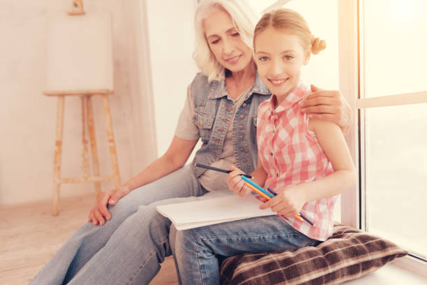 istock Smiling preteen girl posing for camera while drawing 1002879608
