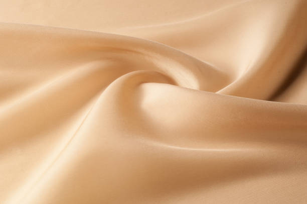 istock Texture background of fabric. Beige fabric. Silk fabric wallpaper texture background pattern in sepia pastel yellow cream beige tint: Lovely natural silk textured textile 1002883800