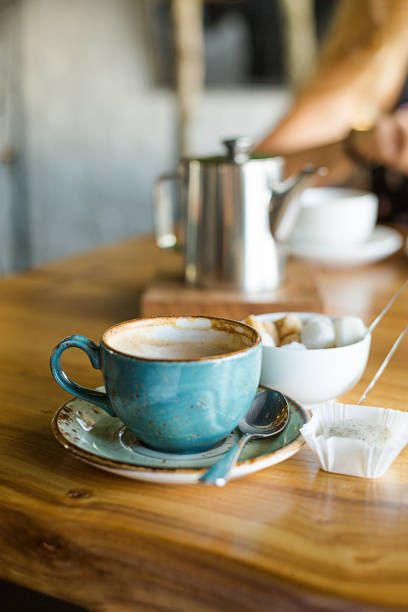 istock Coffeebrak at the restaurant. Blue mug, Cappuccino 1002884016