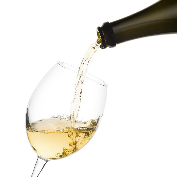 istock white wine poured from a bottle into wine glass on white backgro 1002884844