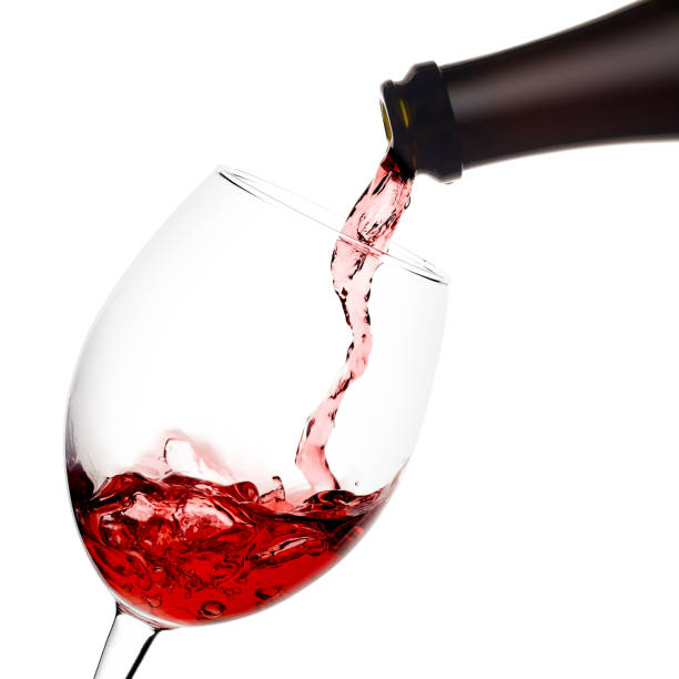 istock red wine poured from a bottle into wineglass on white background 1002884898