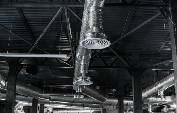istock Ventilation system on the ceiling of large buildings. Ventilation pipes in silver insulation material hanging from the ceiling inside new building. 1002884948