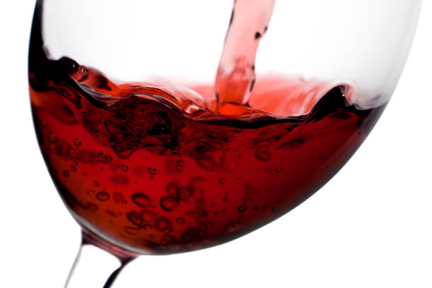 istock red wine poured from a bottle into wineglass on white background 1002885064