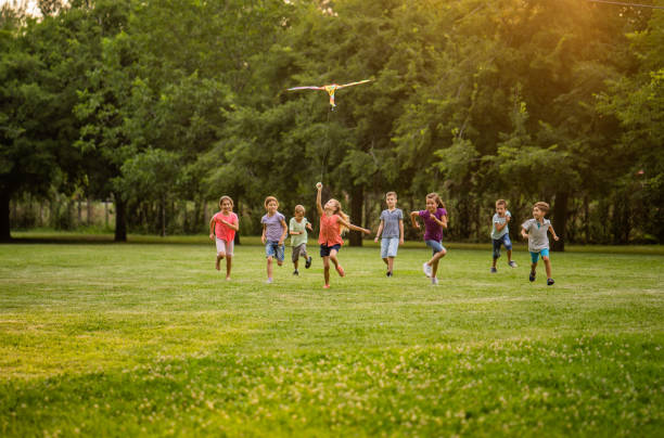 istock Group of children running for a flying dragon 1002890070