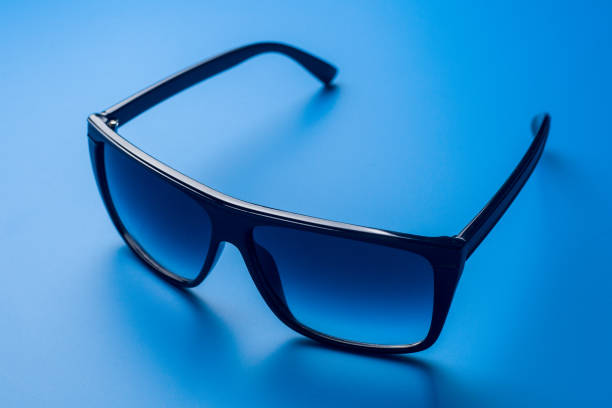 istock Sunglasses on a blue colored  background, summer concept 1002903002