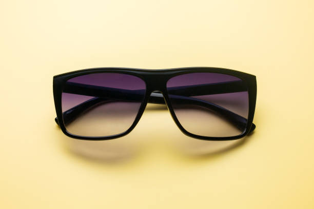 istock Sunglasses on a yellow colored background, summer concept 1002905240