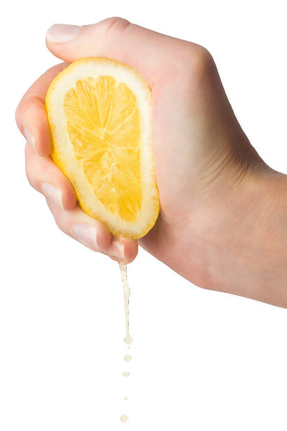 la mano spreme il succo di limone su uno sfondo bianco, isolato - mature women isolated mature adult women foto e immagini stock