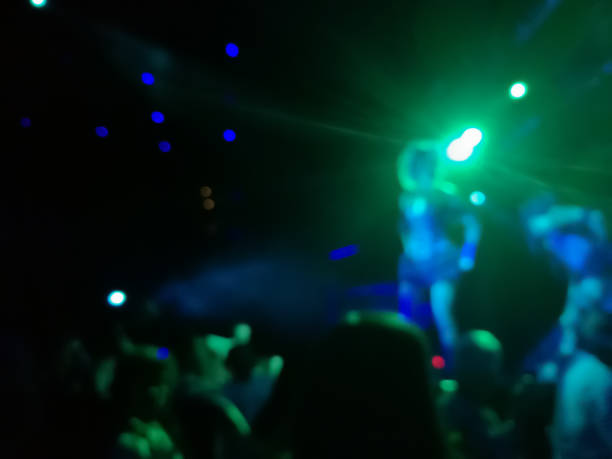 istock Defocused abstract blurred scene of musical light performance in a concert on stage with crowd 1002913556