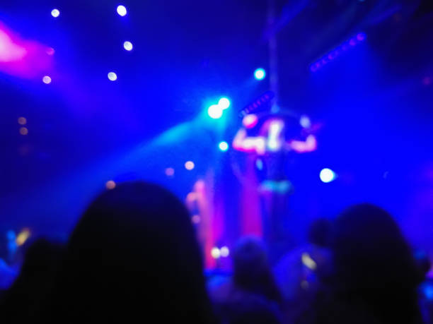 istock Defocused abstract blurred scene of musical light performance in a concert on stage with crowd 1002913644