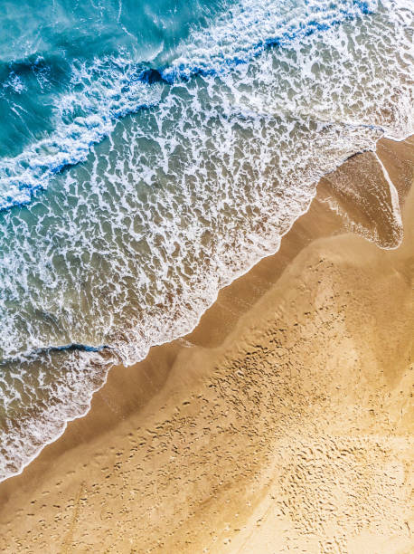 istock Aerial Wiew of Sandy Beach With Waves 1002916916