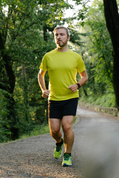 istock Athlete jogging in the woods 1002917702