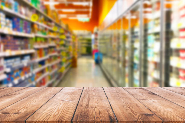 istock Empty wood table top on shelf in supermarket blurred background 1002918080