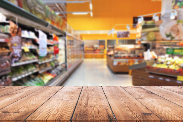 istock Empty wood table top on shelf in supermarket blurred background 1002918312