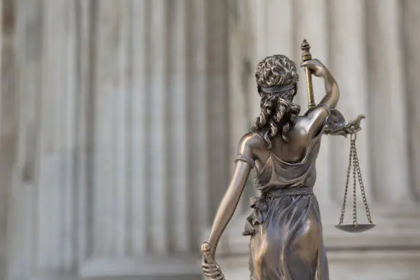 The statue of justice Themis or Justitia, the blindfolded goddess of justice against an ionic order colonnade, as a legal concept