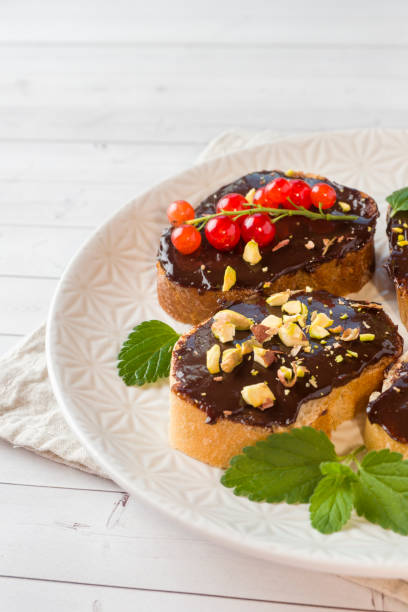 istock Sandwiches with chocolate paste, pistachio nuts and fresh berries on a plate. 1002933902