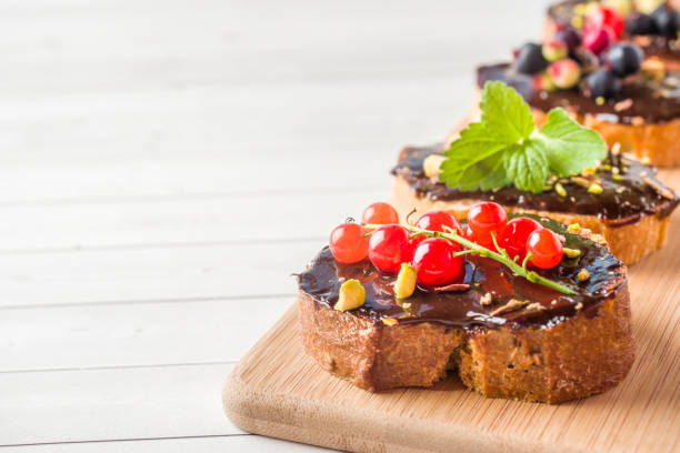 istock Sandwiches with chocolate paste, pistachio nuts and fresh berries on a plate. 1002936842