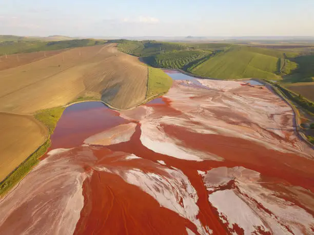 Photo of Aerial view of a reservoir full of red toxic sludge