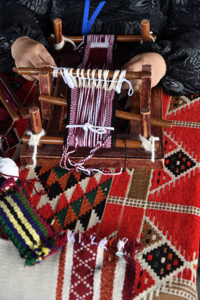 Hands of an arabian weaver A senior arabian woman makes a traditional sadu weaving. Hands of a weaver close-up, focus on the frame. Qatar weaverbird photos stock pictures, royalty-free photos & images