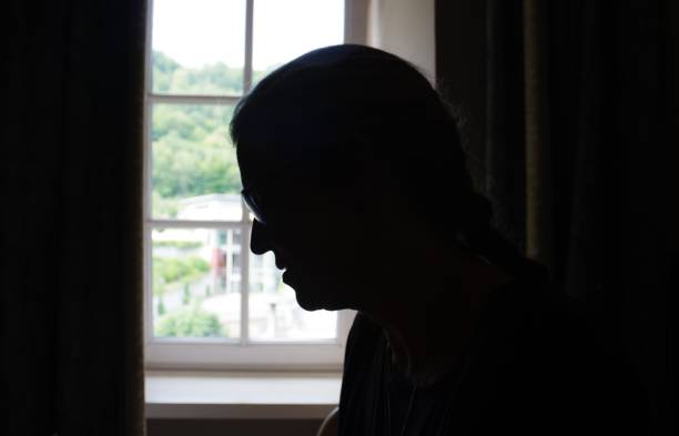 istock Woman standing in window 1002968638