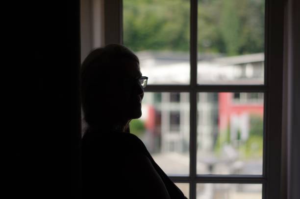 istock Woman standing in window 1002977974