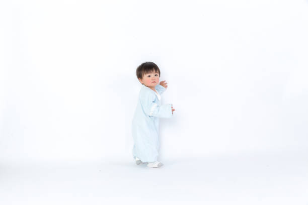 bambino bambino bambino bambino bambino in pannolino fare primi passi isolati su uno sfondo bianco - baby walking child standing foto e immagini stock