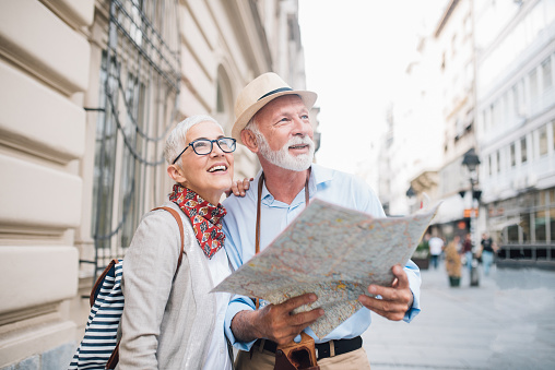Senior pareja sosteniendo un mapa y mirando a la distancia photo