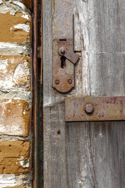 Keyhole in an old paneled wooden door; rusty and weathered. This image has been processed to make a more impactful, dramatic shot.