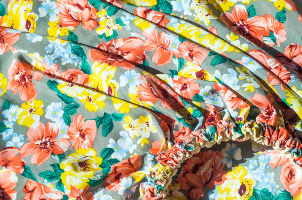 istock Texture, background, pattern. Girl's skirt. Silk fabric with floral pattern. Red Yellow Flowers 1002993720
