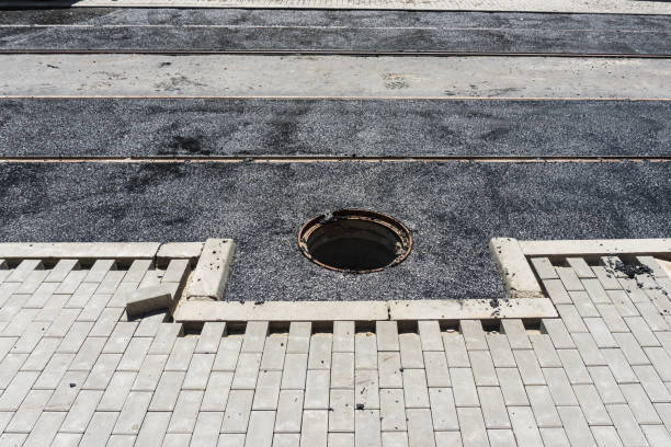 istock A deep manhole without a cover on the road while laying a new asphalt presents a danger to pedestrians and cars 1002996654