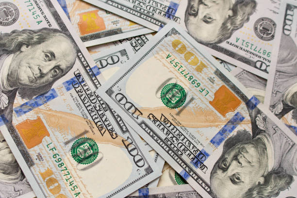 istock A lot of hundred dollar bills scattered on the table 1003047506