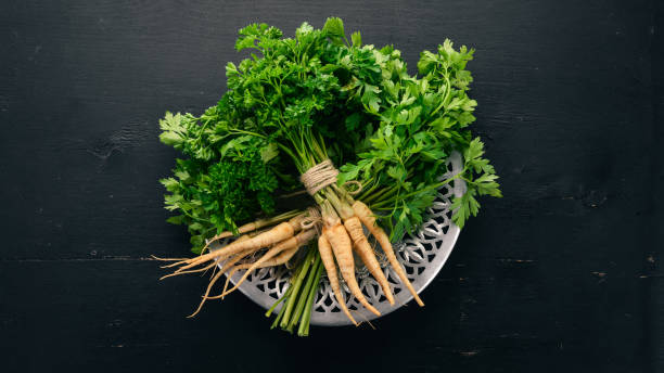 istock Fresh green parsley. Root parsley. On a wooden background. Top view. Copy space. 1003061228