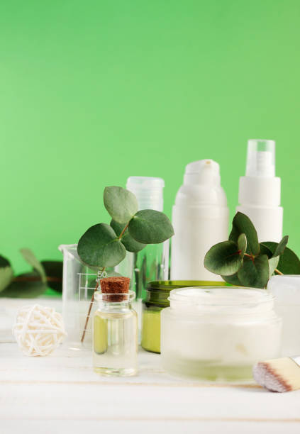 istock Healthy herbal cosmetic products on table with green vertical background and aromatic eucalyptus leaves. 1003067954