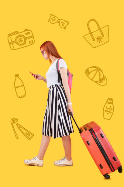 istock Serious traveler looking at the screen of her gadget while carrying a suitcase 1003089440