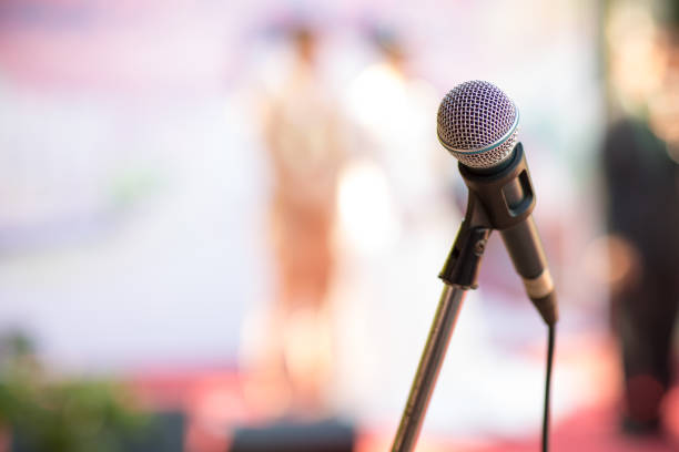 istock microphone in concert hall or conference room soft and blur style for background. 1003089910