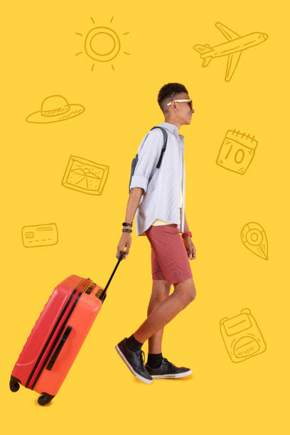 istock Relaxed student being in the airport and carrying his suitcase 1003093320