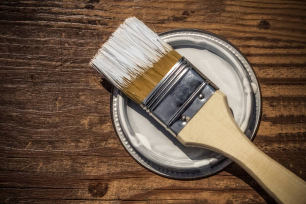 istock Brush on the lid from under the paint, wooden background with copy space 1003094428