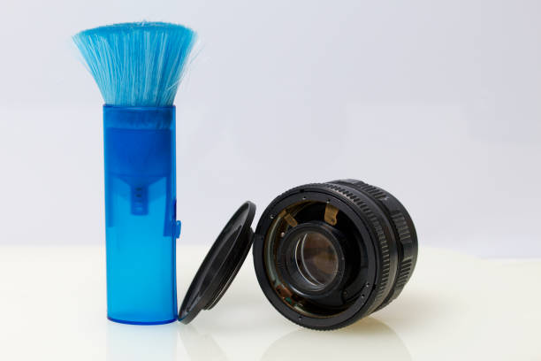 istock On the table is an old disassembled lens and a brush for brushing dust. On a white background. 1003094998