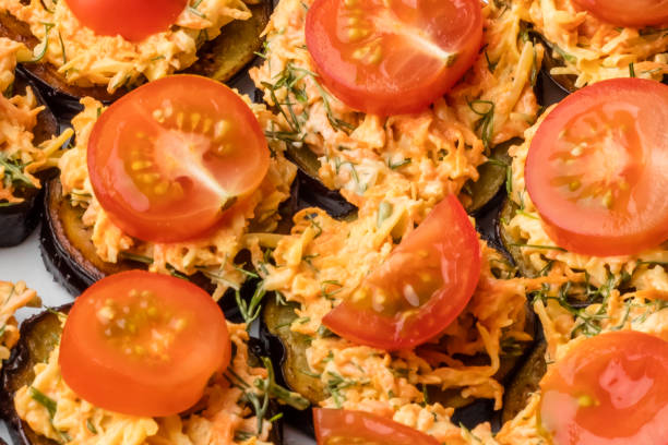 istock Baked eggplants with vegetables, carrots and greens, decorated with tomato slices 1003095158