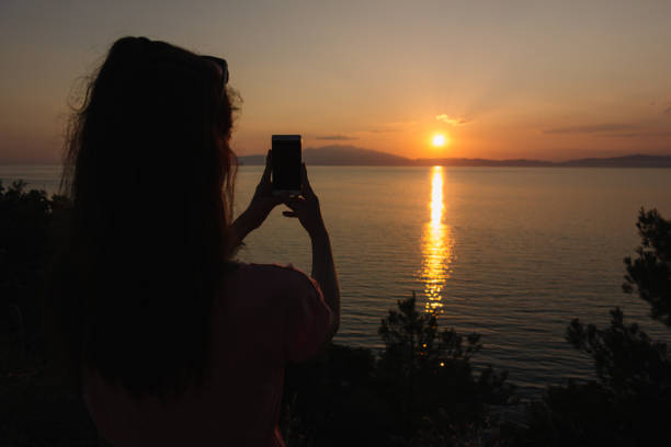 istock Woman photographing the sunset 1003097732