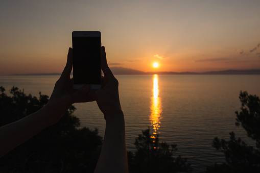 Woman photographing the sunset