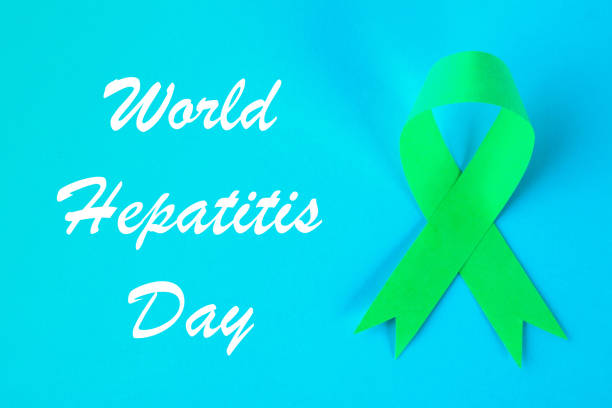 istock World Hepatitis Day. June 28th. Jade green ribbon on a blue table. 1003107424