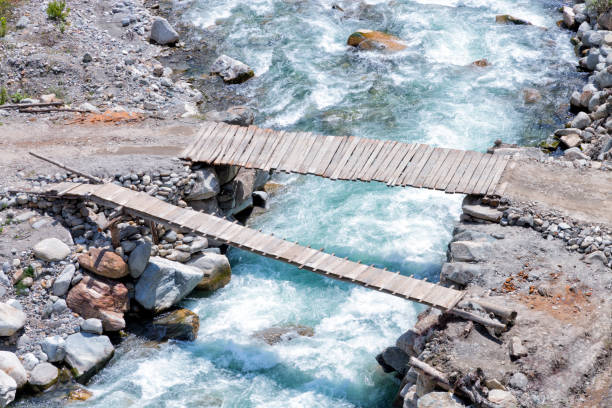 istock wooden planks bridge crossing over fast flowing mountain river 1003108268