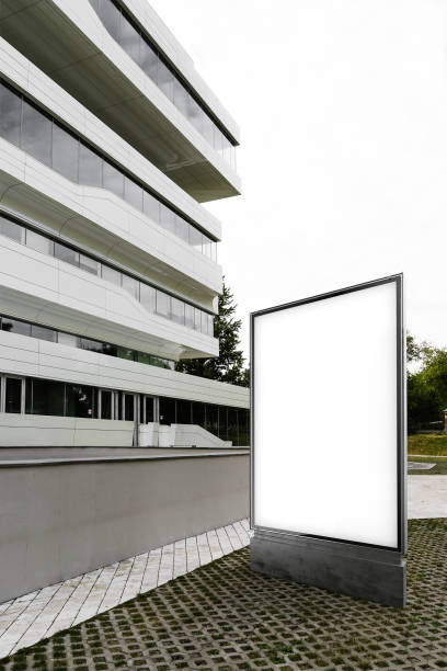 istock Close up of blank banner next to white skyscraper, side view. 3d rendering 1003110644